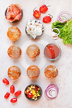Mini burger buns topped with sesame seeds and various fillings