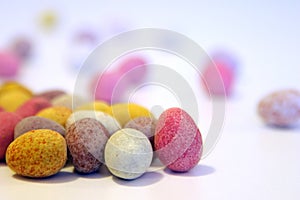 Mini candy chocolate eggs on a white surface