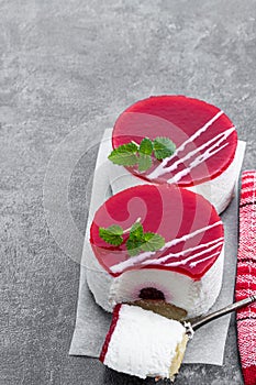 Mini cheesecakes with red fruits jam topping on gray background