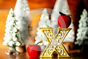 Mini Christmas trees with x of the gold with apple in the forest. Bokeh lights with wooden background