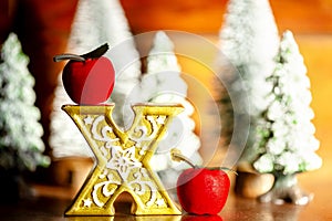 Mini Christmas trees with x of the gold with apple in the forest. Bokeh lights with wooden background