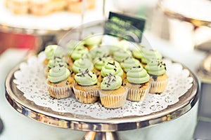 Mini cupcakes with green icing on a silver tray