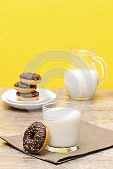Mini donuts covered with chocolate glaze served with bottle, jug, glass of milk. Stack of tasty sweet sugar creamy or