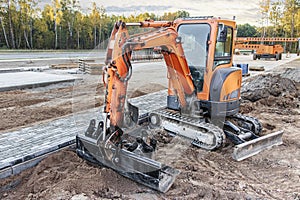 Mini excavator at the construction site. Compact construction equipment for earthworks