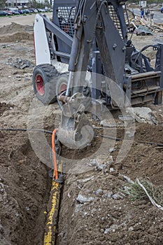 Mini excavator digging up a electrical cables from trench