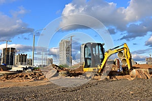 Mini excavator during earthmoving at construction site. Backhoe dig ground for the construction of foundation and laying sewer