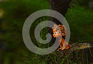 Mini figrure of boy sitting beside big tree