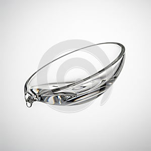 A mini glass dappen dish for acrylic liquid, floating in mid air horizontally on a solid white background