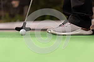 Mini golf - The player prepares to hit the ball with the club