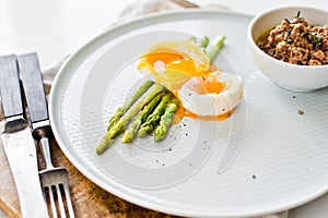 Mini grilled asparagus with egg and tuna. White background, side view.