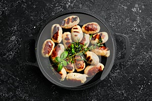 Mini grilled sausages on a frying pan. Barbecue. Meat menu.