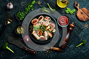 Mini grilled sausages on a frying pan. Barbecue. Meat menu.
