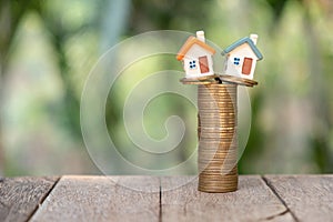 Mini house model and stack of coins. Business growth.  Property investment and house mortgage financial real estate concept
