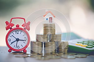 Mini house on stack of coins, Concept of Investment property, Investment risk and uncertainty in the real estate housing market