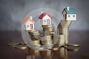 Mini house on stack of coins, Concept of Investment property, Investment risk and uncertainty in the real estate housing market