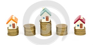 Mini house on stack of coins, Concept of Investment property, Investment risk and uncertainty in the real estate housing market.