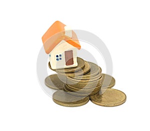 Mini house on stack of coins, Concept of Investment property, Investment risk and uncertainty in the real estate housing market.