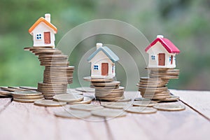 Mini house on stack of coins, Concept of Investment property, Investment risk and uncertainty in the real estate housing market