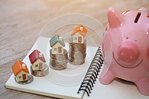 Mini house on stack of coins, Concept of Investment property, Investment risk and uncertainty in the real estate housing market