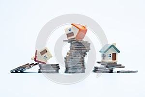 Mini house on stack of coins  on white background., Concept of Investment property, Investment risk and uncertainty in the real