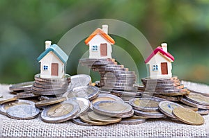 Mini house on stack of coins  on white background., Concept of Investment property, Investment risk and uncertainty in the real