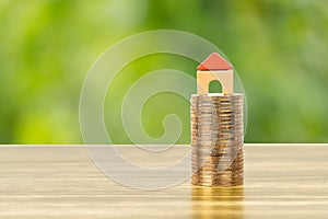 Mini model house on coins stack concept for mortgage, finance, and saving