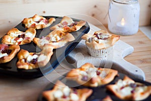 Mini muffin pizza freshly baked on a wooden cutting board