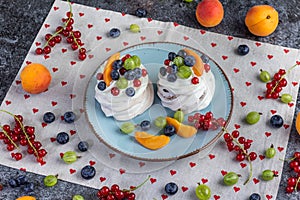 mini pavlovs with garden fruits currants, gooseberries, blueberries, apricots on a table full of fruits