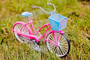 Mini pink toy bike on grass.bicycle on meadow. spring summer travel sport. Active life style