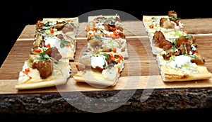 Mini pizza appetizers on wooden cutting board