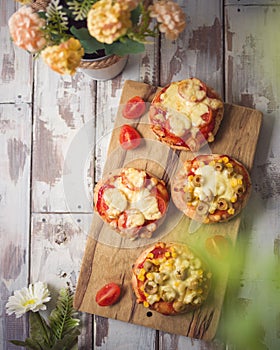 Mini pizza on wooden board. Top view from above photo