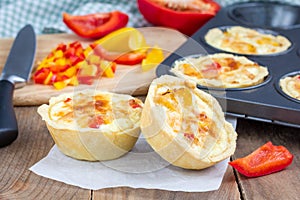 Mini quiche with chicken and bell pepper on wooden table