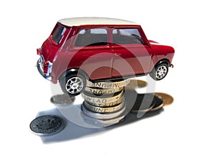 Mini red toy car on coins stack