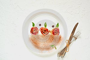 Mini rose tarts with apples and mint leaves on the white plate