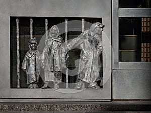 Mini sculpture of a historic family with a child at the bottom of a metal front door