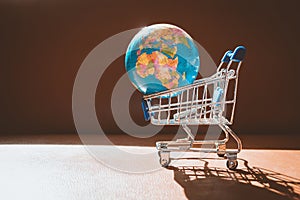 Mini shopping cart contain small earth using as e-commerce and b