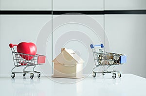 Mini shopping cart,Red heart,Coins stack with home model piggy bank,Finance and money saving concept