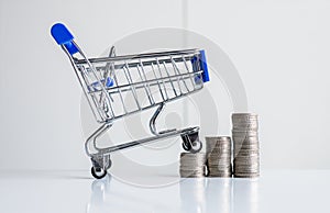 Mini shopping cart with step of coins stacks,Finance and money shopping concept