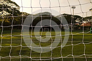 Mini-soccer Futsal field in view from behind goal net. Another goal compititor are in square view of net