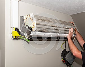 Mini split air conditioner system on wall, being fixed photo