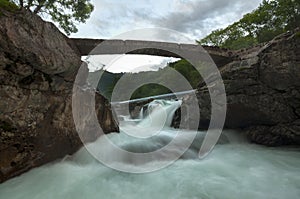 Mini stone bridge over a waterfall