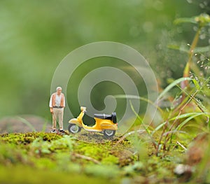 Mini toy at outdoor with blurred background. Old man travelling concept design.