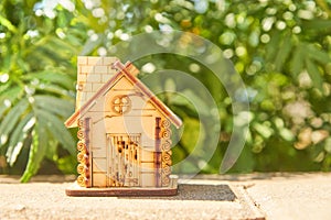 Mini toy wooden house on summer nature background. concept of mortgage, construction, rental, using as family and property concept