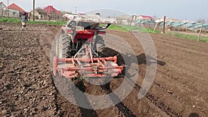 Mini tractor cultivates a field on a farm