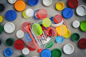 Mini trolley with colored plastic caps ready to be recycled. Plastic recycling concept