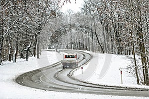 Mini truck passing on a highway with snow slush and snow fall