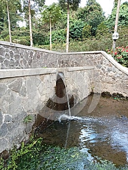 Mini waterfall in outdoor garden with green moss