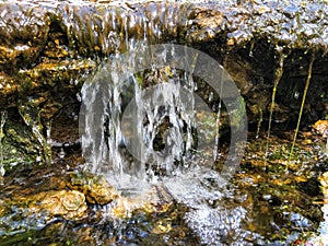 Mini waterfall on the rocks on a sunny day