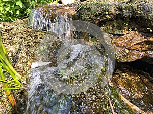 Mini waterfall on the rocks on a sunny day