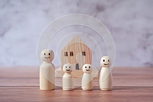 Mini wood house model and wooden figure of people in family include parents and children on wood table,Planning buy Real Estate